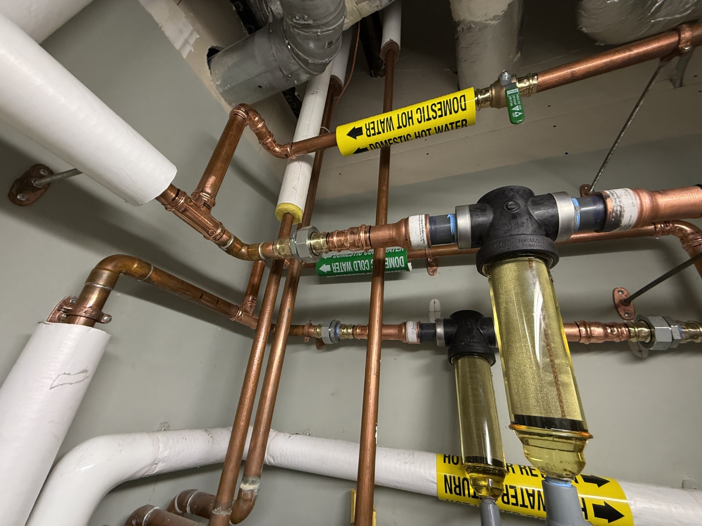 Copper piping installation with labeled domestic hot and cold water lines