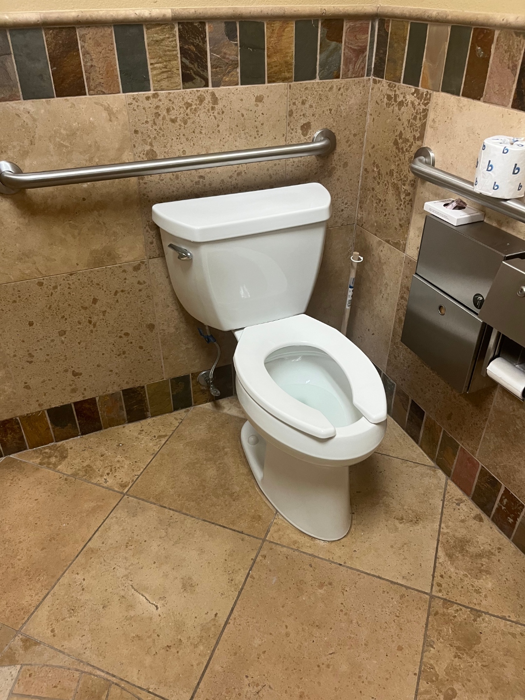 Commercial toilet installation with travertine tile by Haltex Plumbing
