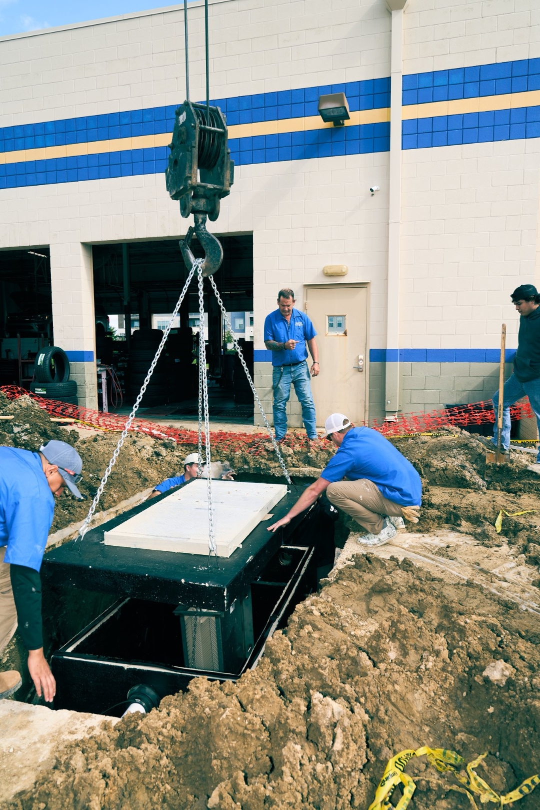 Haltex crew lowering a grease trap into position at a commercial site