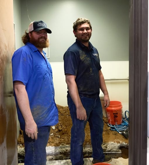 Two Haltex crew members smiling during an indoor remodeling plumbing job