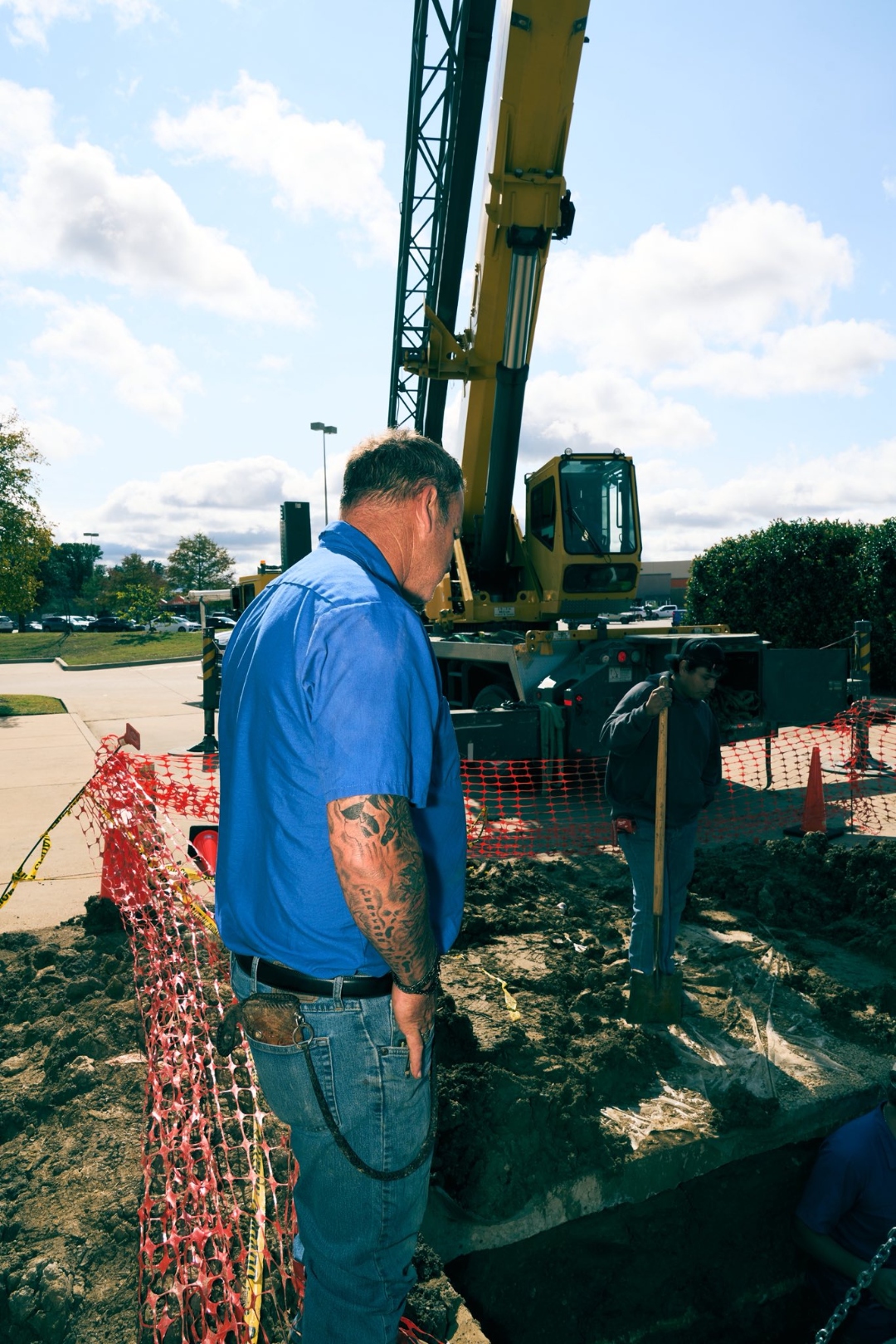 Senior Haltex crew member supervising a crane operation for grease trap installation