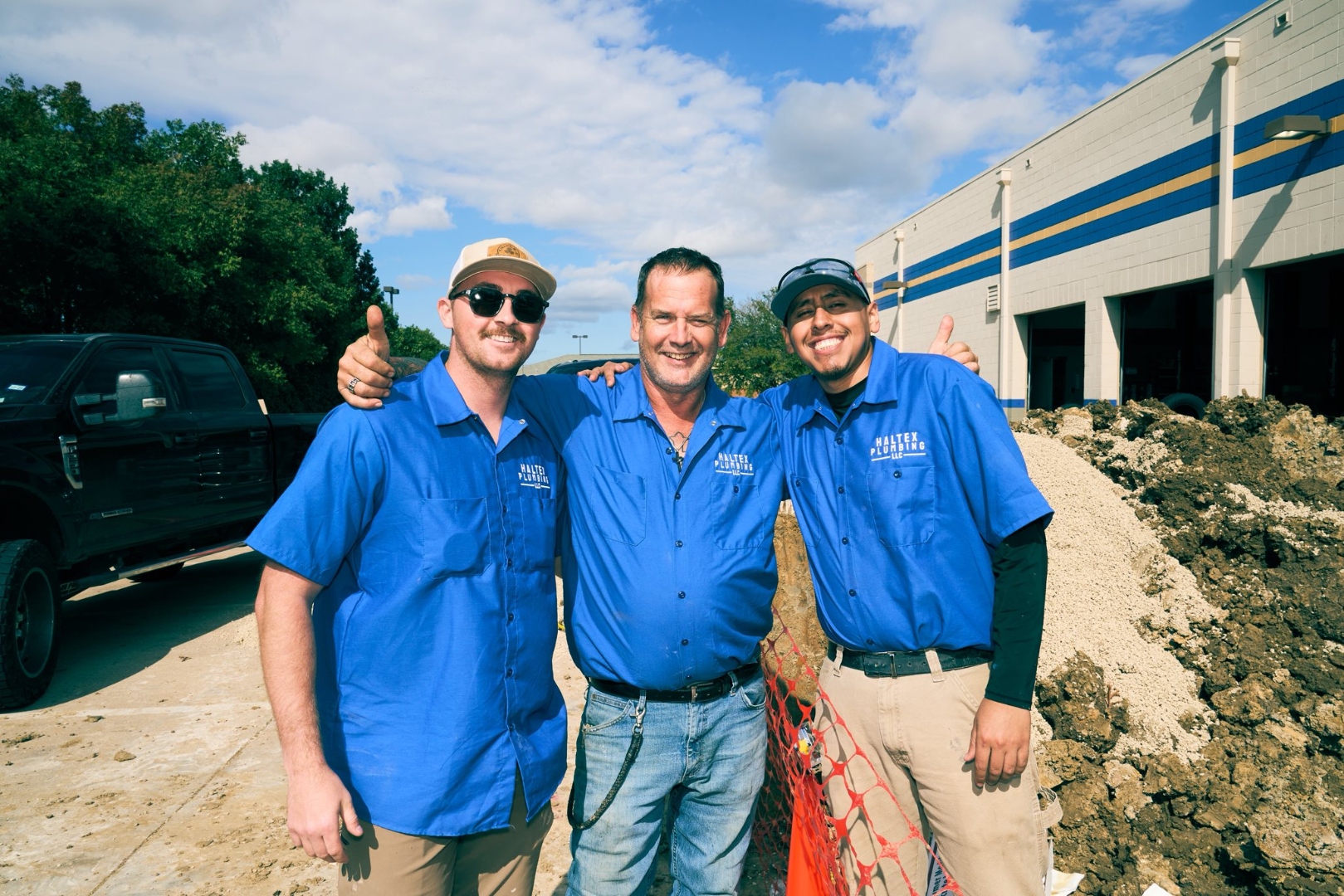 Haltex Plumbing team members giving thumbs up on a job site