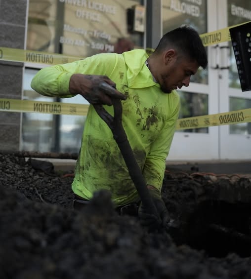 Haltex crew member excavating at a commercial building entrance for sewer line access